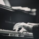 grey pic of man playing a piano