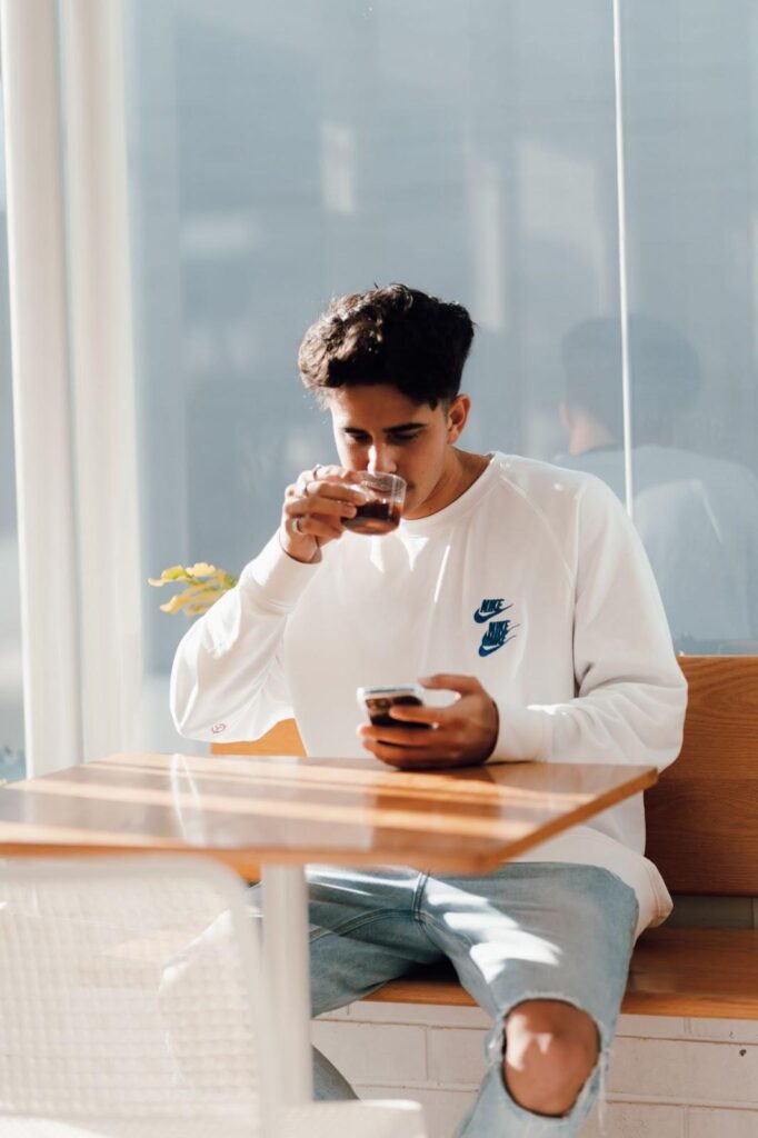 Boy drinking coffee and using a dating app