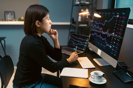 Woman analyzing cryptocurrency trends on screen