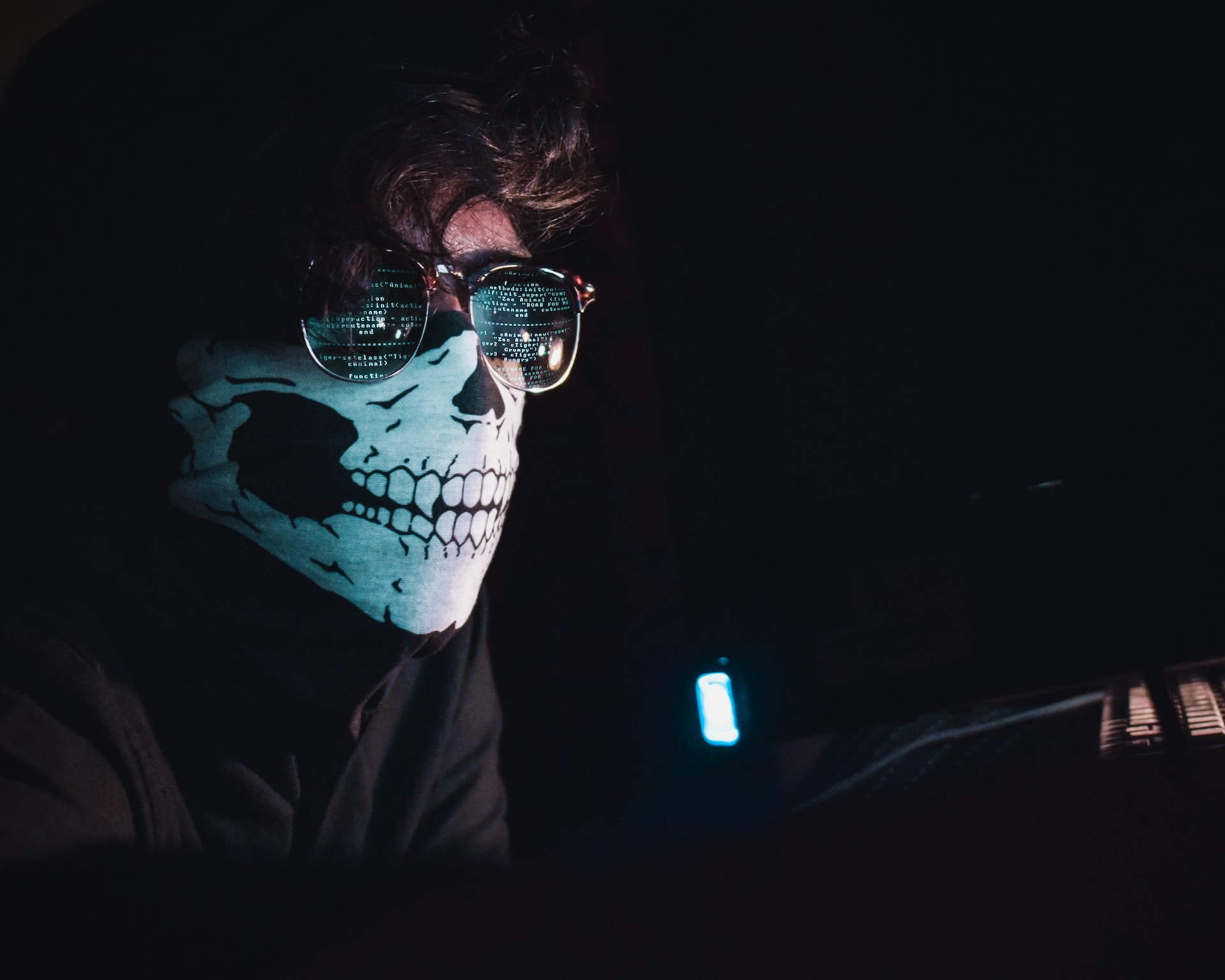 Man wearing a skull mask and working on website security