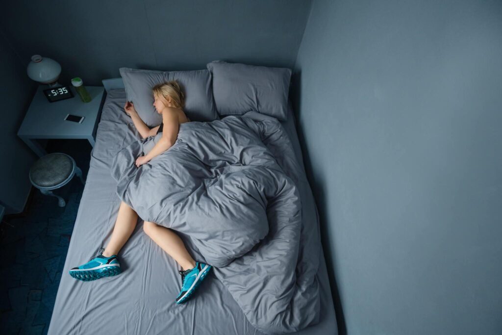 Girl sleeping on bed in gym clothes