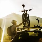 Man putting bicycle ion car roof rack