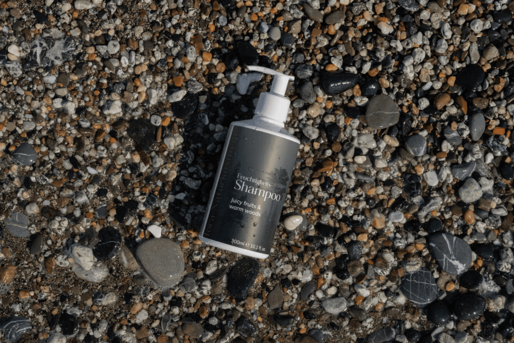 Shampoo bottle on the wet ground or beach