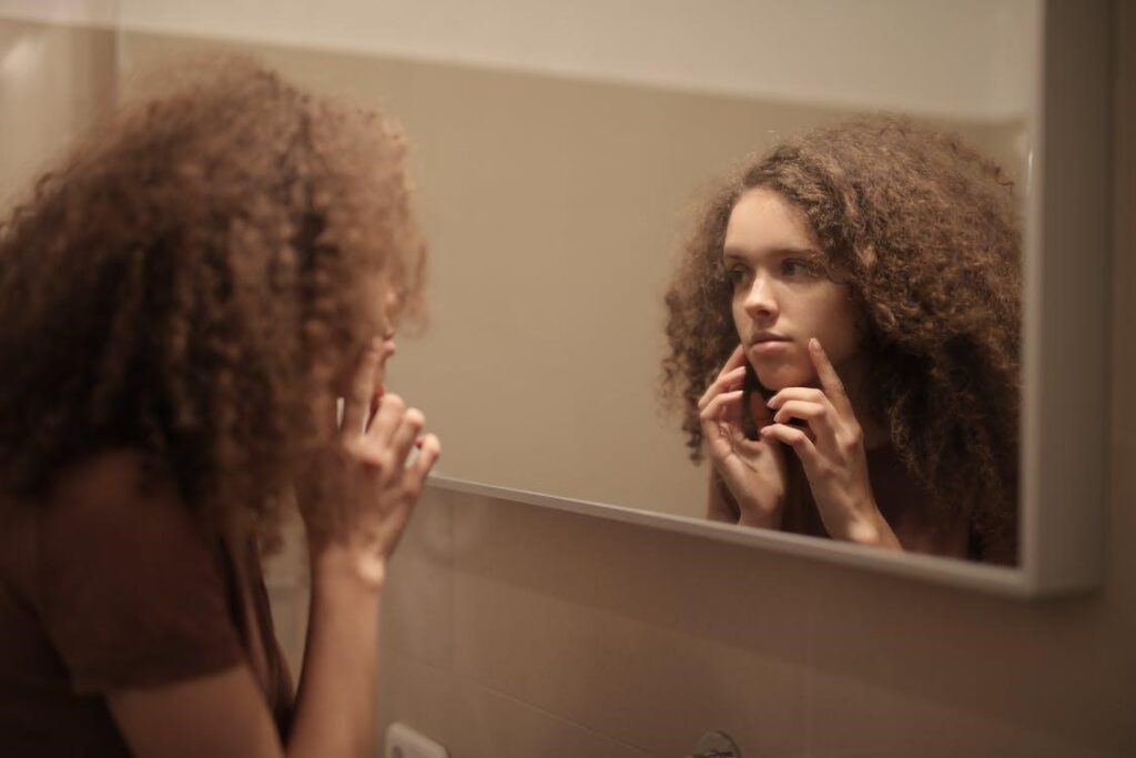 curly hair girl looking in mirror