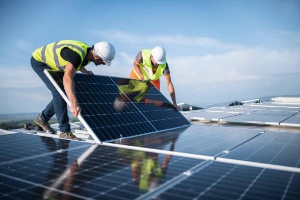Two workers installing solar panels for green and clean energy