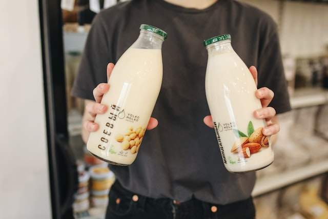 Man holding two bottles of packed soy milk