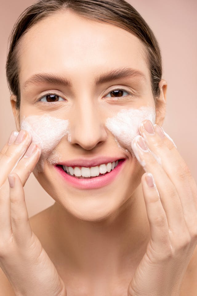 woman using cleanser on face