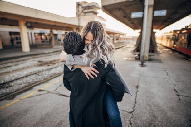 Couple hugging each other on railway platform